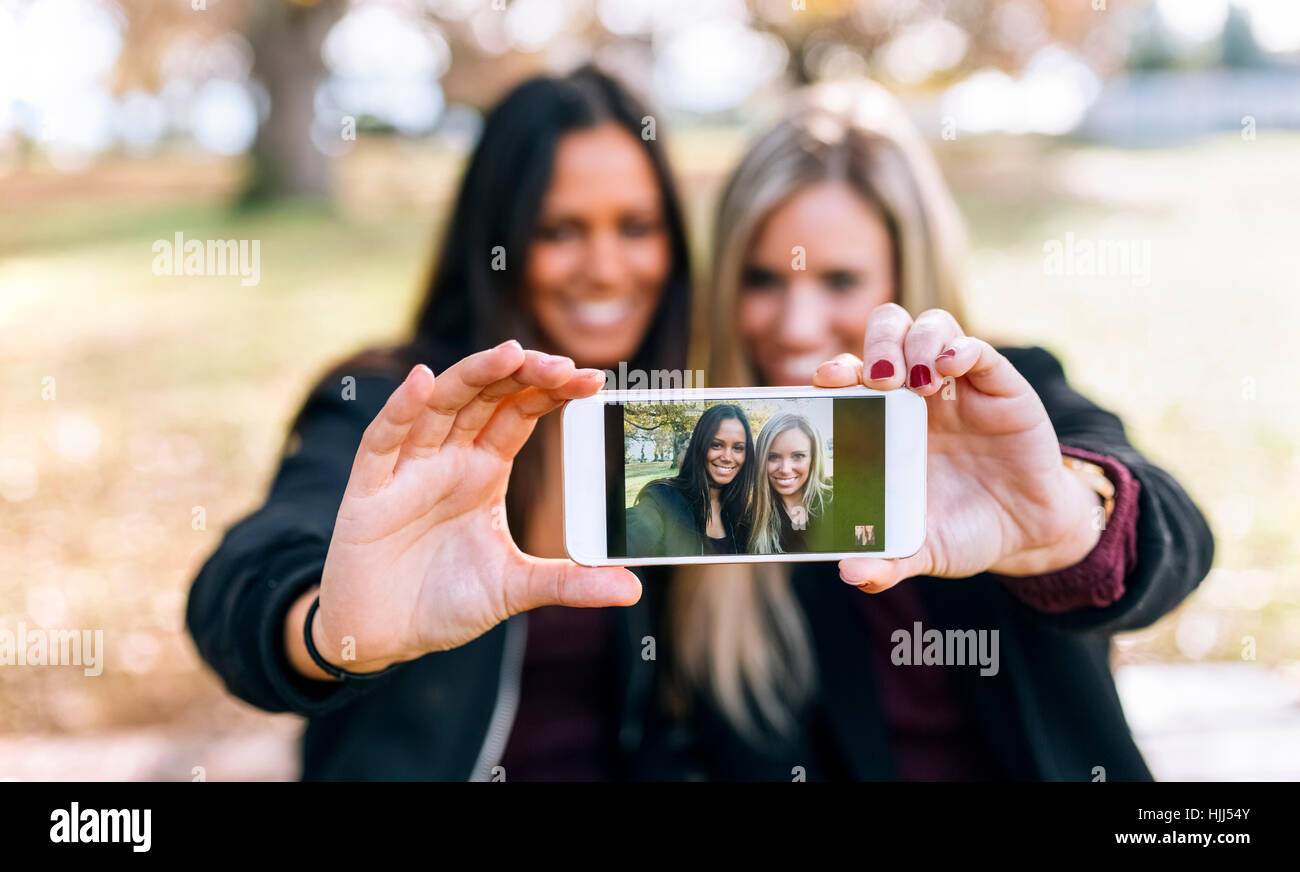 Cell phone photo de deux jeunes femmes smiling Banque D'Images