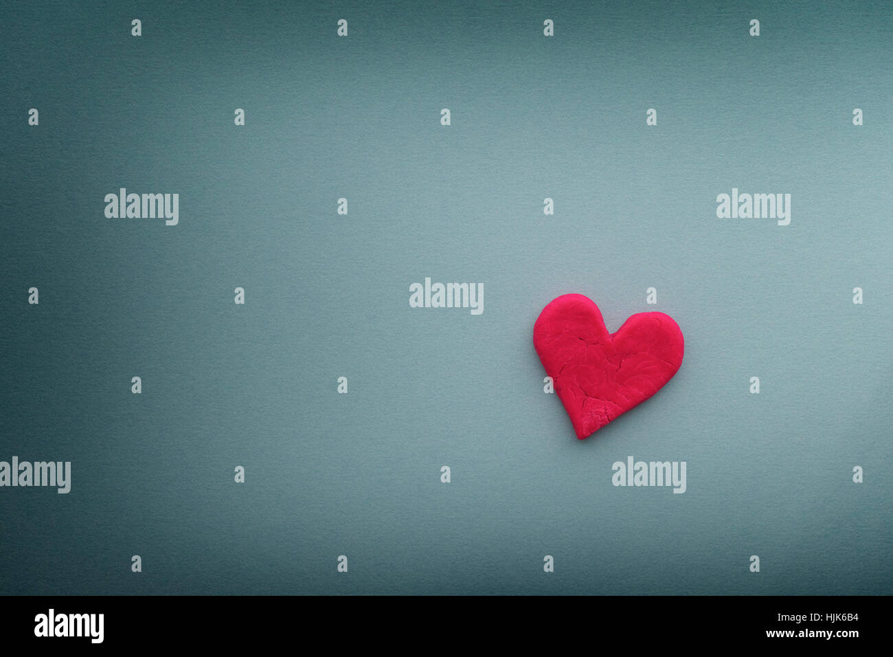 Coeur rouge avec des petites fentes sur fond bleu. Close up. Banque D'Images