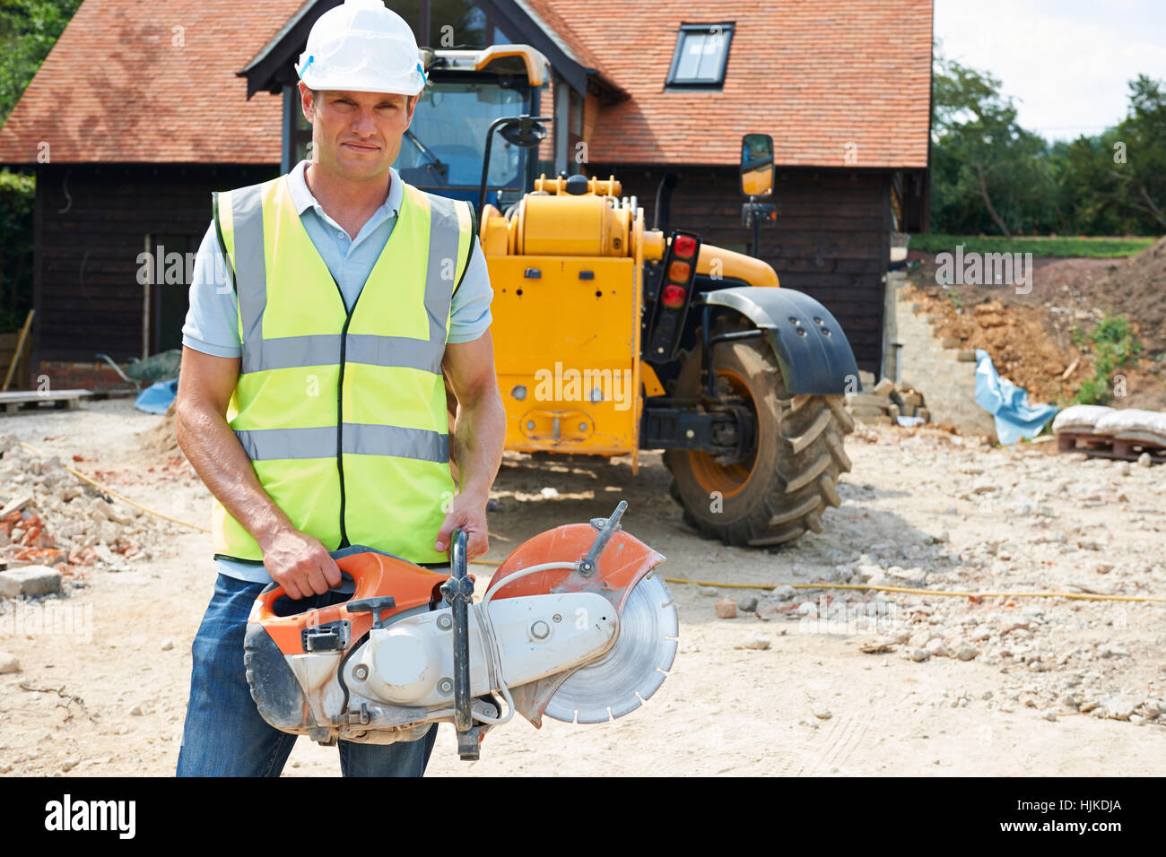 Construction Worker Holding sur le site scie circulaire Banque D'Images