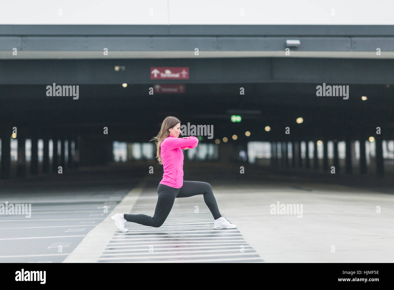 Woman stretching à un garage de stationnement Banque D'Images