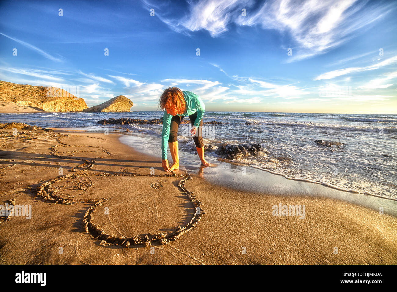 L'Espagne, Almeria, femme rayures coeur dans le sable de plage au parc naturel de Cabo de Gata Banque D'Images