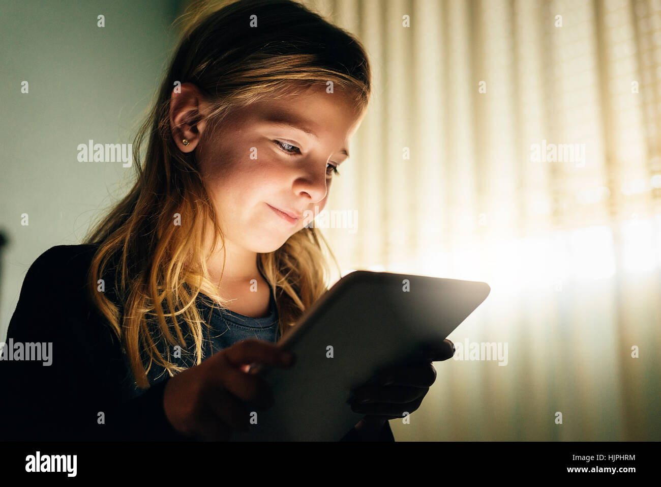 Sweet blondie fille jouant sur une tablette Banque D'Images