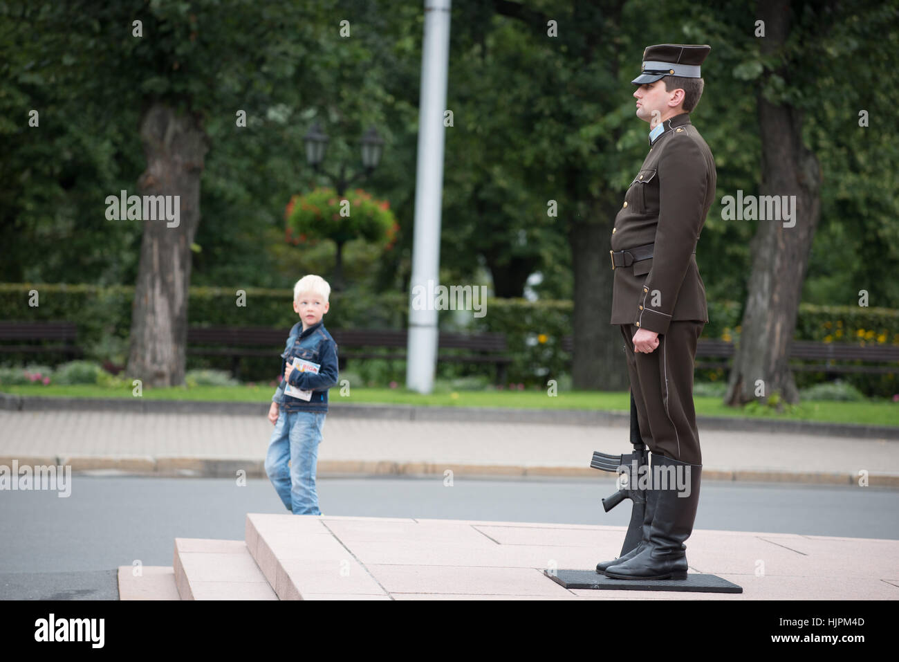 Un jeune garçon blond à la recherche à la garde d'honneur du Monument de la liberté, Riga, Lettonie Banque D'Images