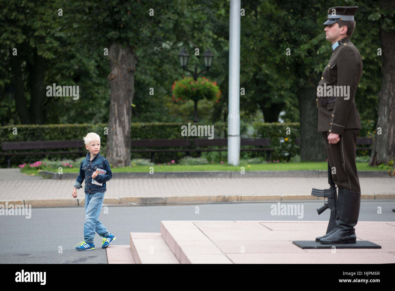Un jeune garçon blond à la recherche à la garde d'honneur du Monument de la liberté, Riga, Lettonie Banque D'Images