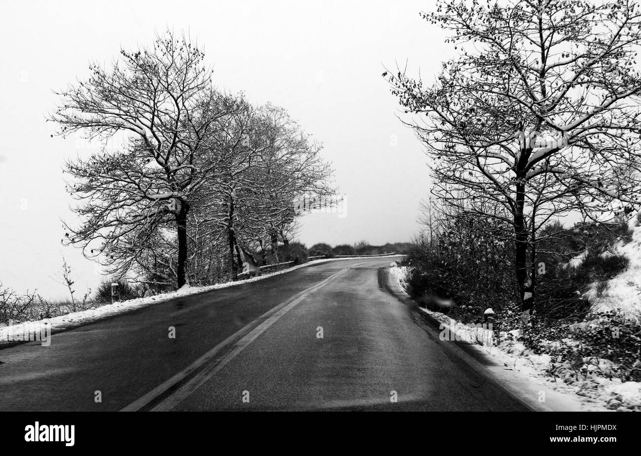 La neige sur une route de montagne avec arbres à Ioannina, Grèce. Banque D'Images