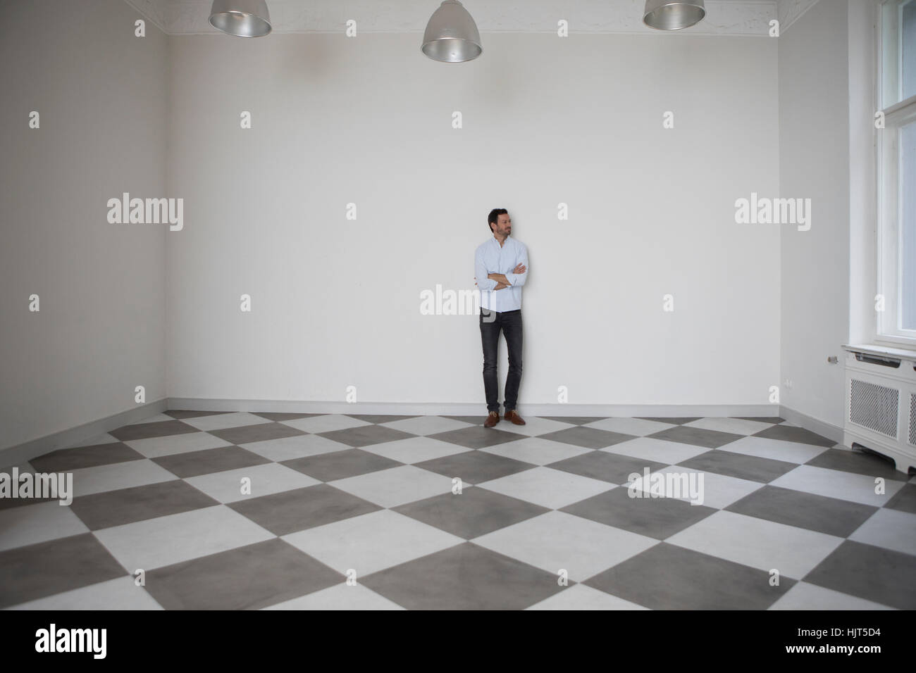 Homme debout dans la salle vide à la recherche d'une fenêtre Banque D'Images