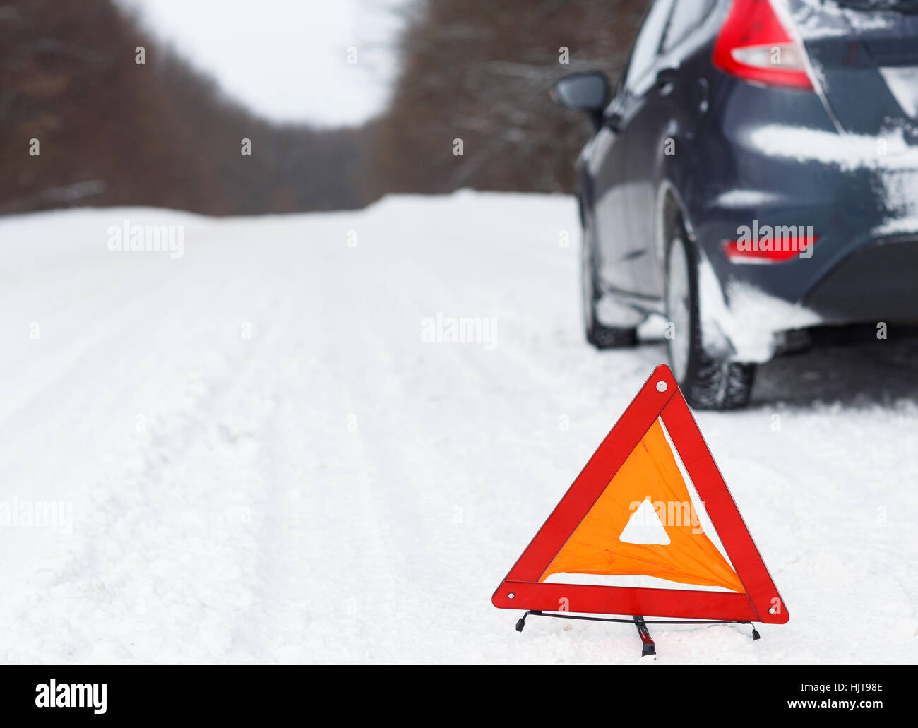 Le transport, l'hiver et véhicule concept - gros plan du triangle d'avertissement rouge avec une voiture en panne Banque D'Images