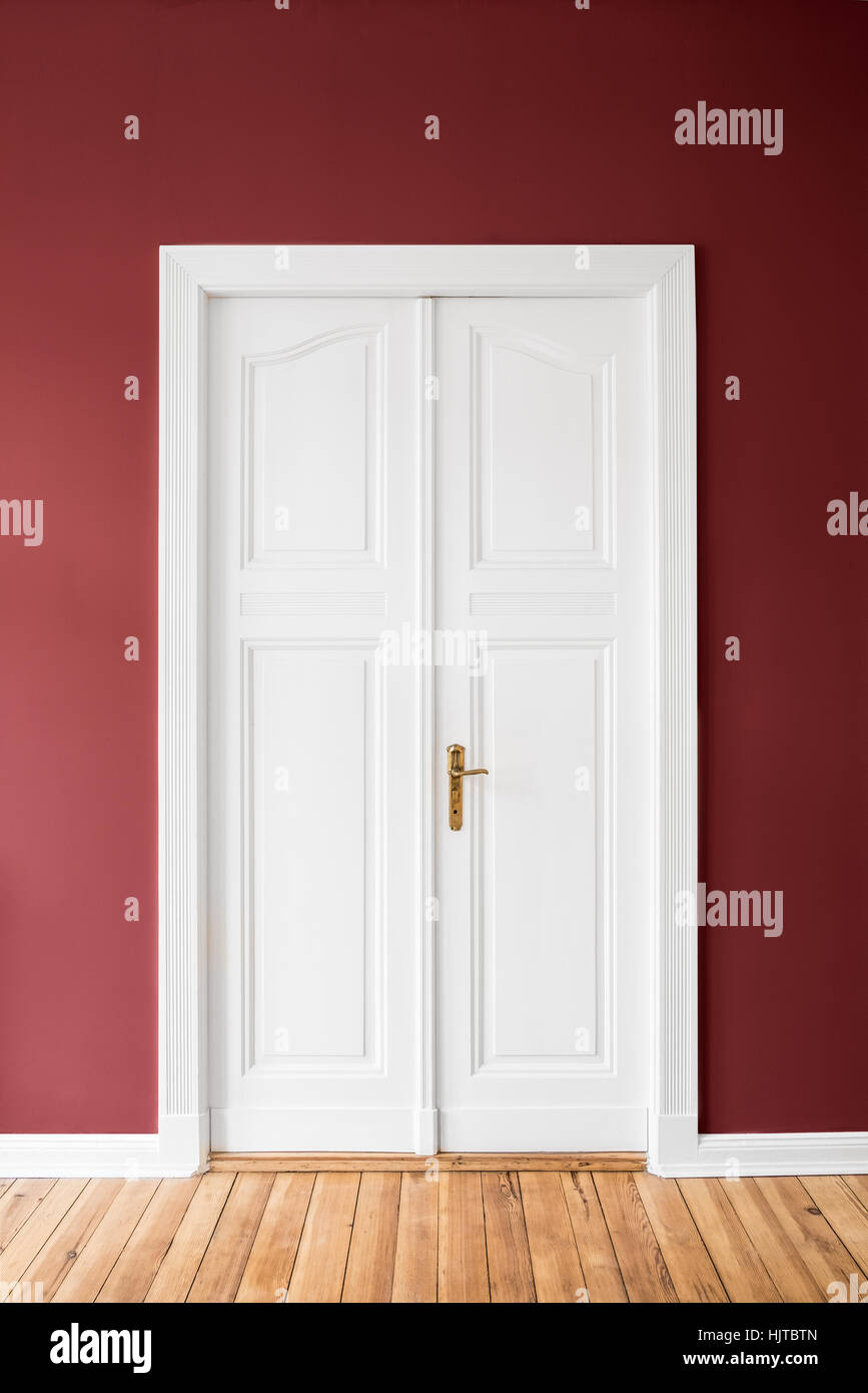 La porte double en bois sur mur rouge - Appartement rénové intérieur Banque D'Images