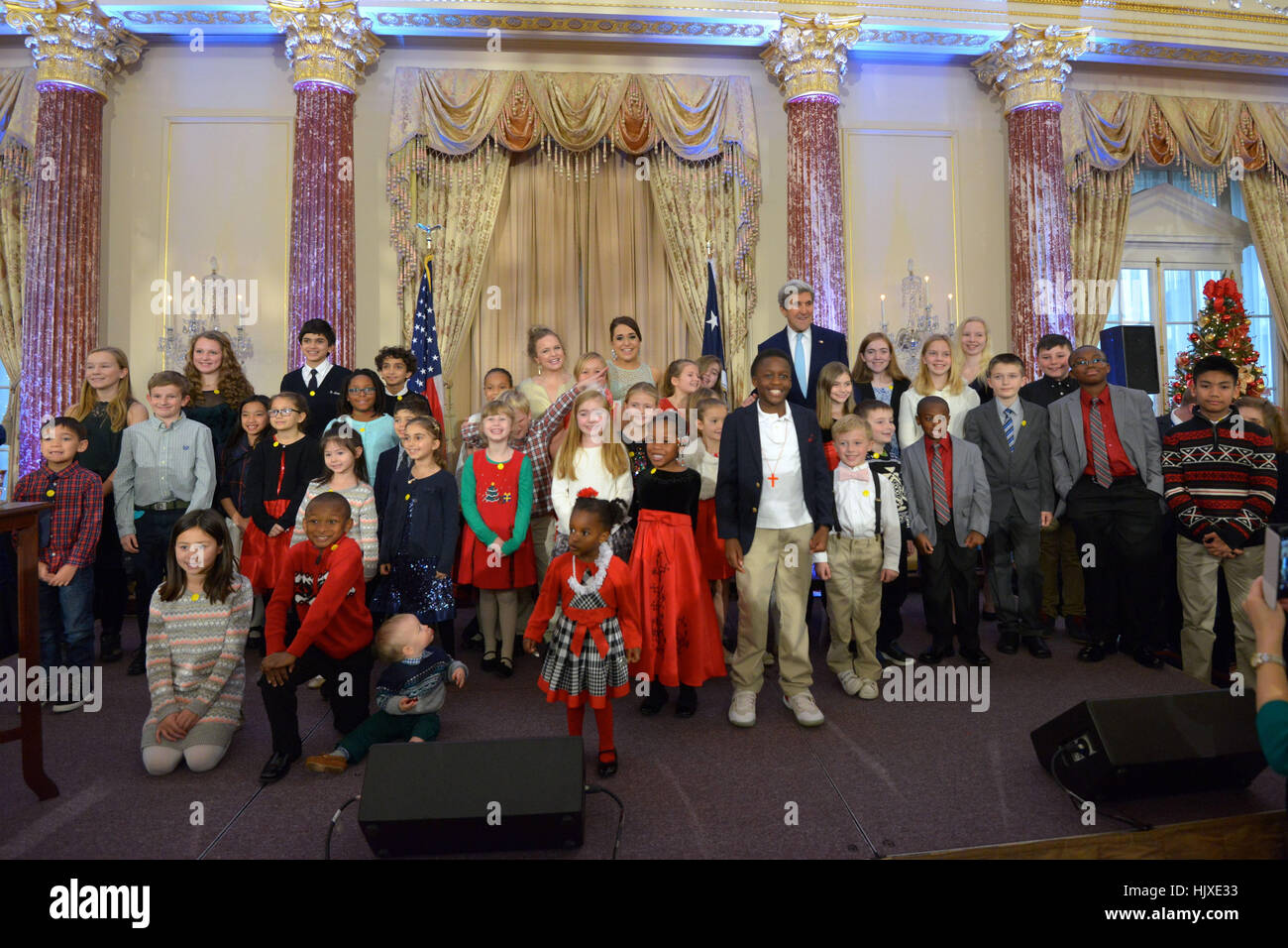 Le secrétaire d'Etat John Kerry pose pour une photo avec des enfants d'employés du gouvernement des États-Unis sur l'affectation à des postes non accompagnés dans le monde entier à l'assemblée annuelle de diplomatie de maison pour les vacances à la réception, le Département d'État des États-Unis à Washington, D.C., le 13 décembre 2016. Banque D'Images