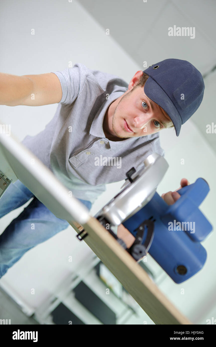 Jeune homme à l'aide de scie circulaire Banque D'Images