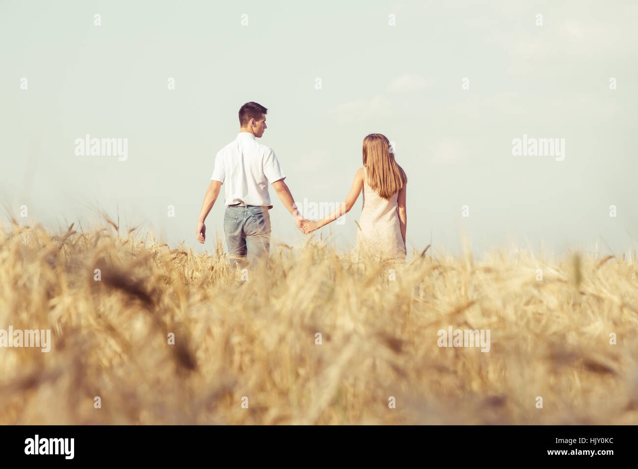 Happy young couple en train de marcher ensemble au champ de blé Banque D'Images