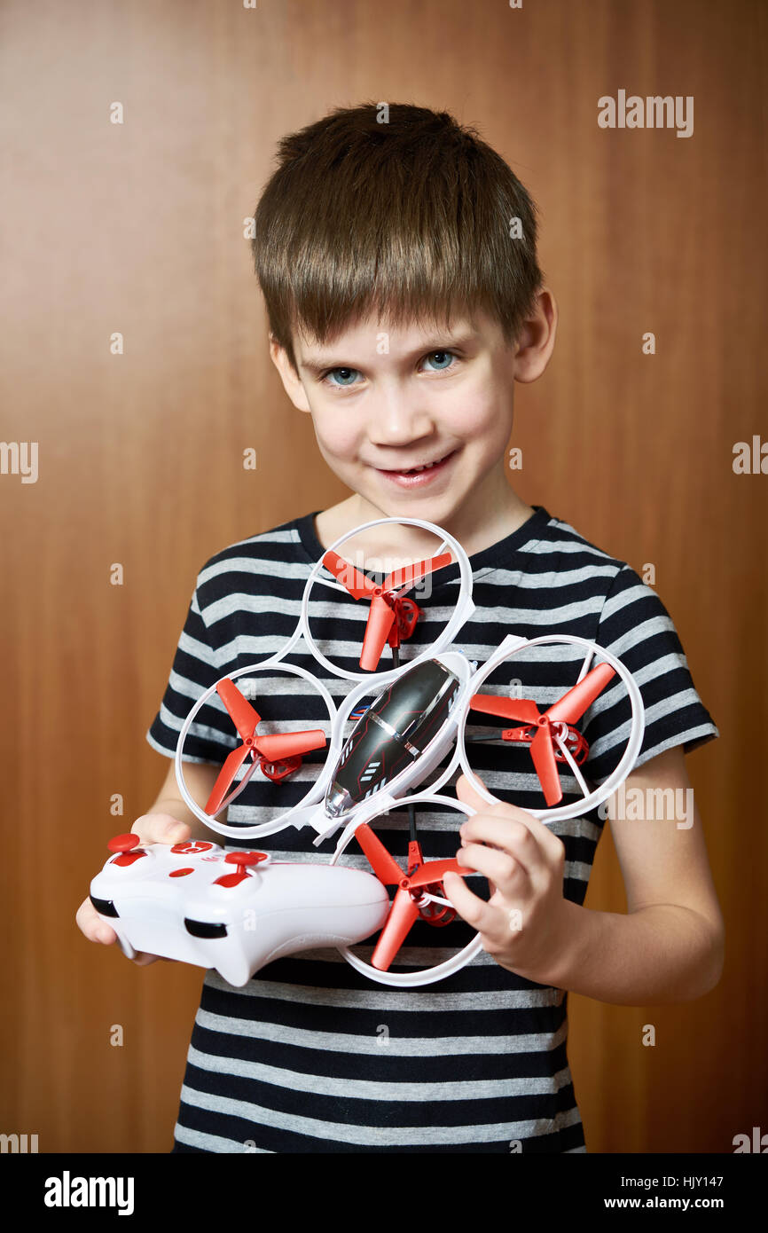 Petit garçon avec toy quadrocopter drone à la maison Banque D'Images