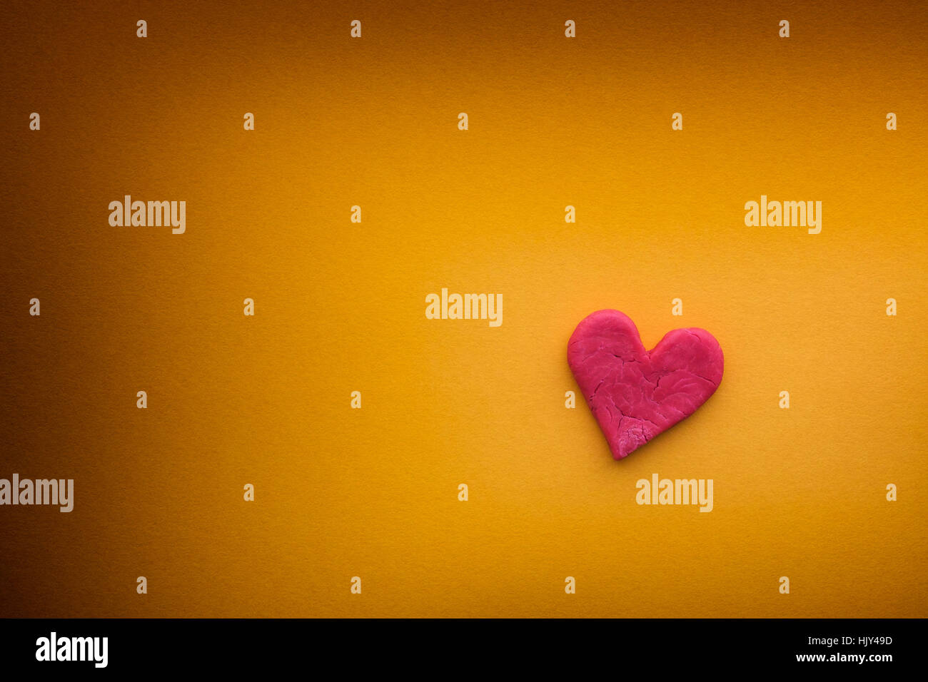 Coeur rouge avec des petites fentes sur fond jaune. Close up. Banque D'Images