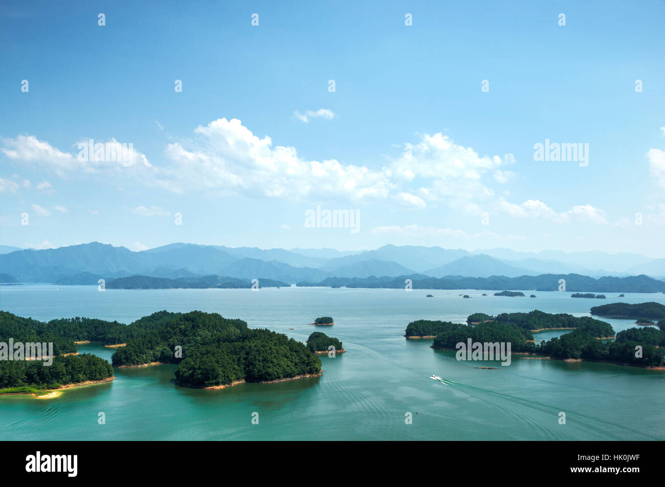 Un bateau blanc faire son chemin à travers Mille-Îles (Qiandao Lake), Chunan, Zhejiang, Chine Banque D'Images