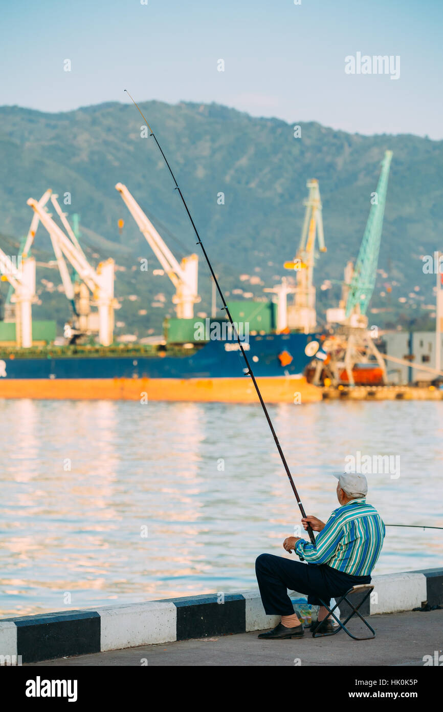 Vieil homme près de Port de pêche quai sur soirée ensoleillée au coucher et au lever du soleil l'heure à Batoumi, Géorgie, l'Adjarie Banque D'Images