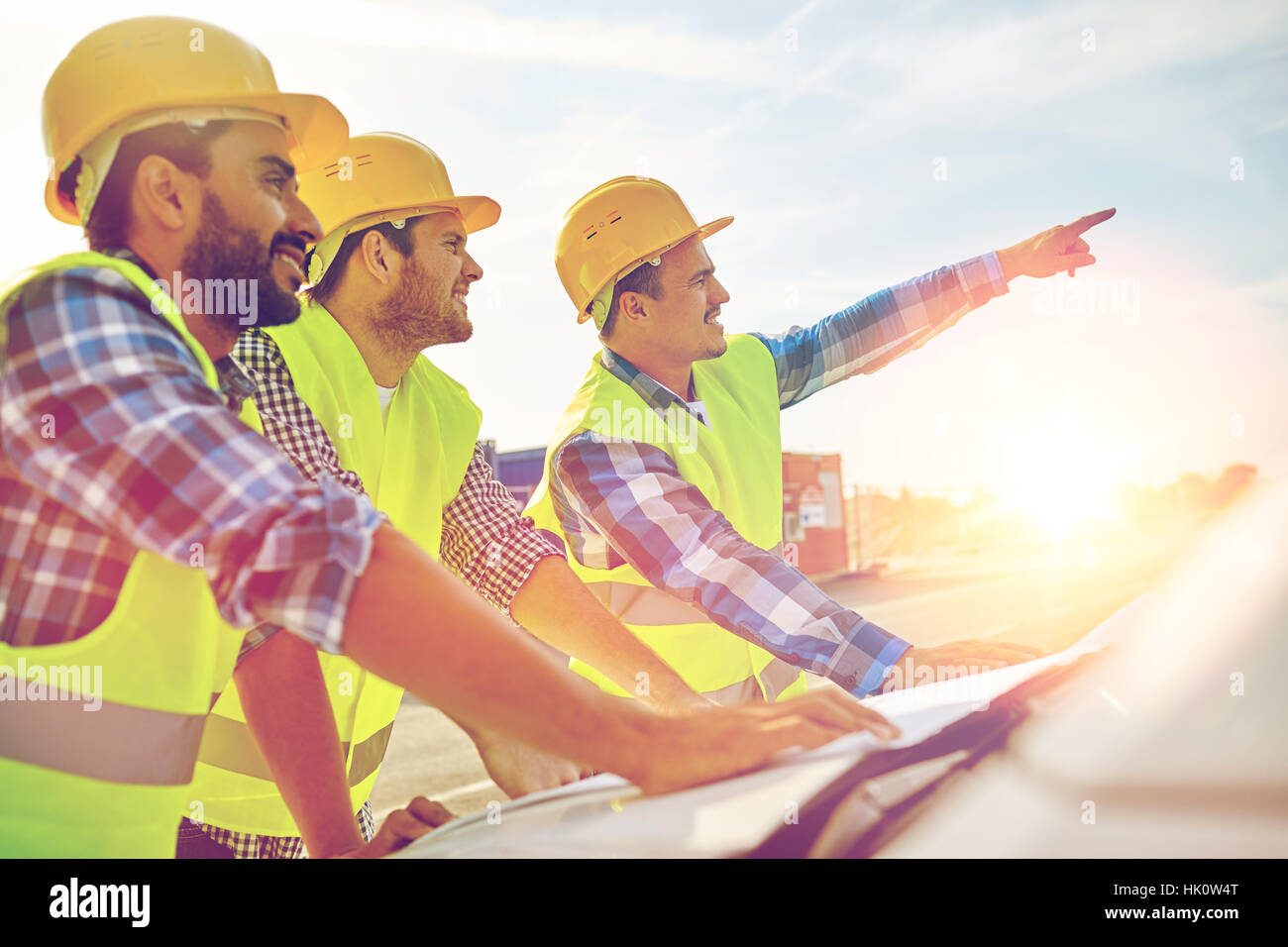 Close up de constructeurs avec le plan sur un capot de voiture Banque D'Images