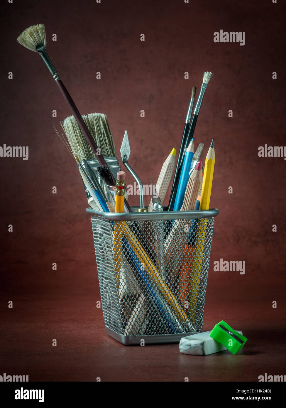 Divers outils de l'artiste et d'accessoires en métal sur fond rouge foncé Banque D'Images