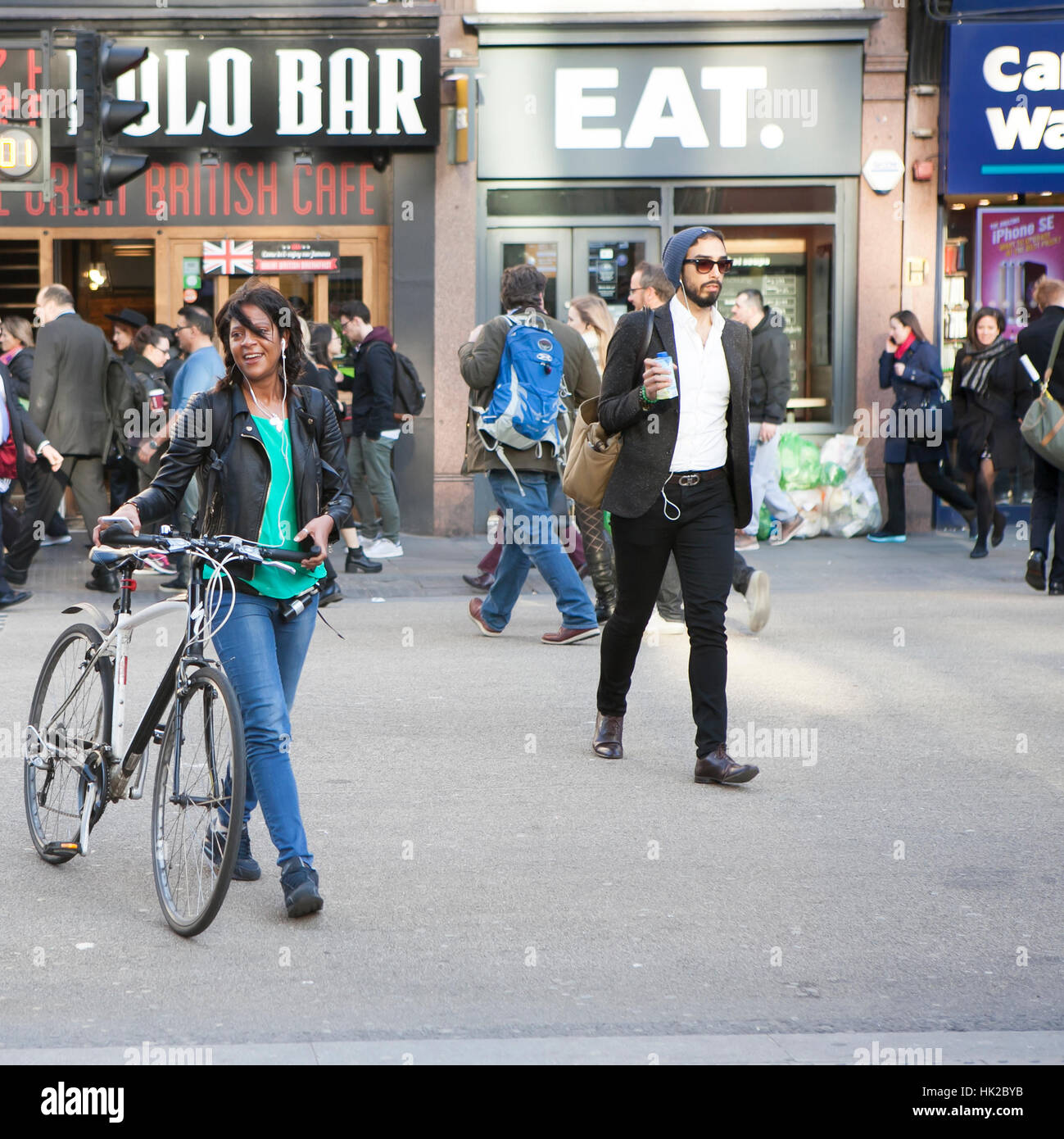 Londres, Royaume-Uni - 27 août 2016 : smiley girl in a t-shirt vert traverser la route avec un vélo Banque D'Images