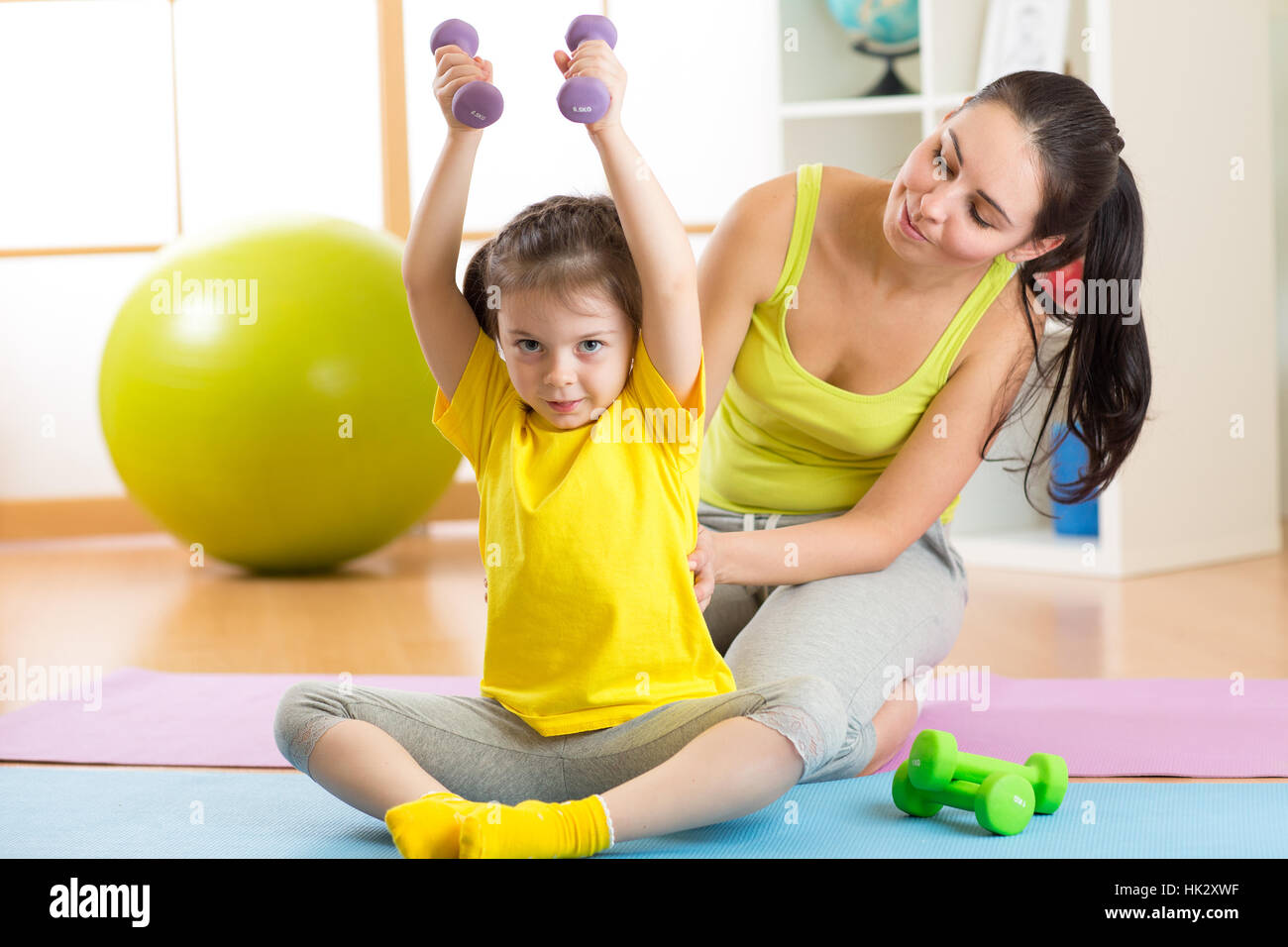 La famille de la mère et enfant fille sont engagés dans fitness, yoga, l'exercice à la maison ou salle de sport Banque D'Images
