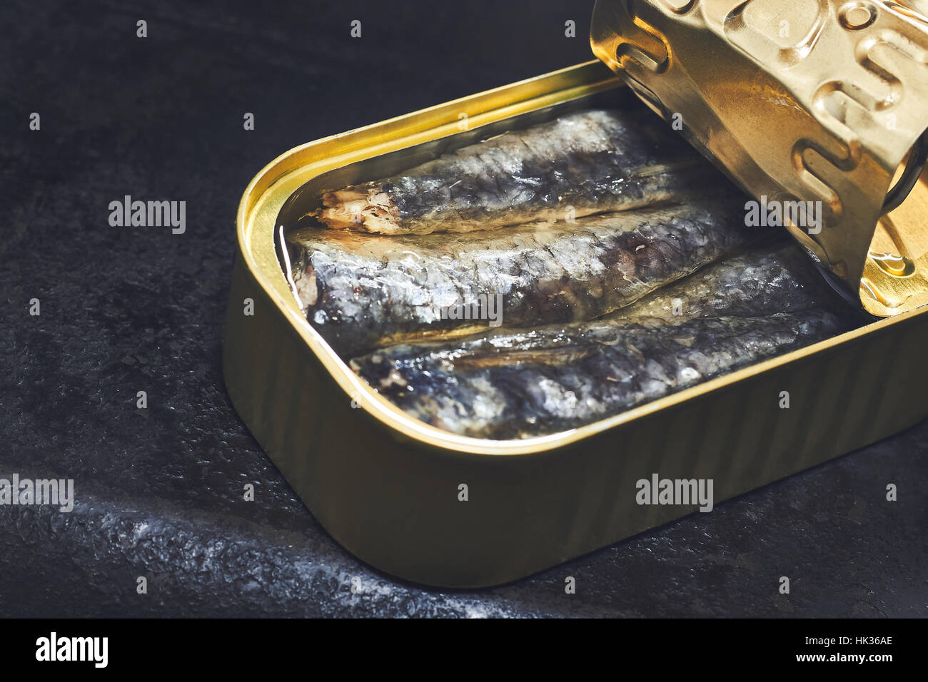 Les sardines en boîte sur fond rustique noir Banque D'Images