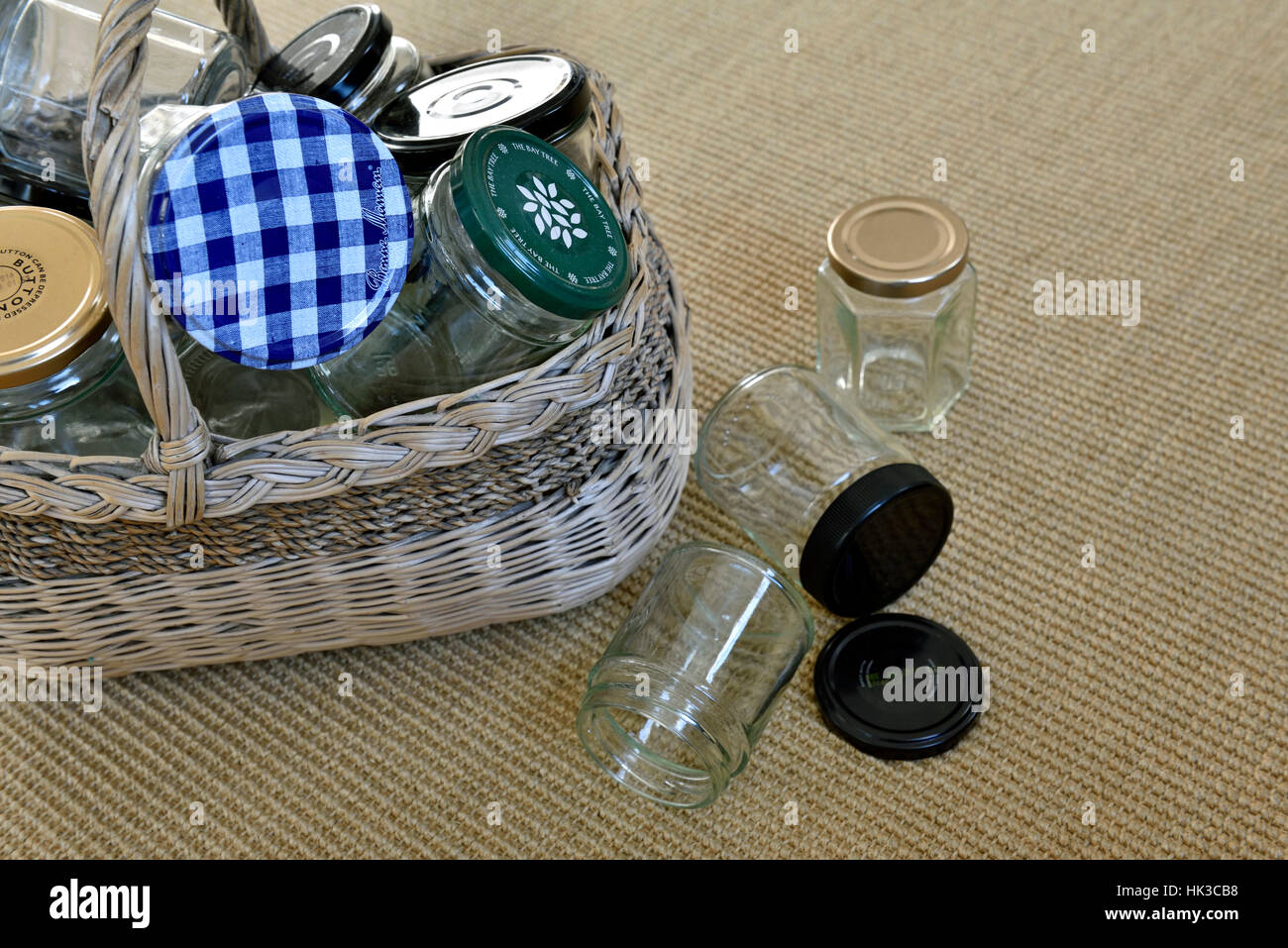 Dans des bocaux en verre vide vintage panier en osier avec un peu tombé sur le plancher, pour réutilisation dans faire de la confiture ou de recyclage Banque D'Images
