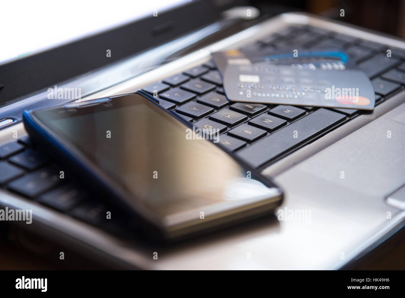 Selective focus sur le clavier du téléphone mobile et des cartes de crédit bancaires par internet paiement en ligne concept dans les tons sombres Banque D'Images