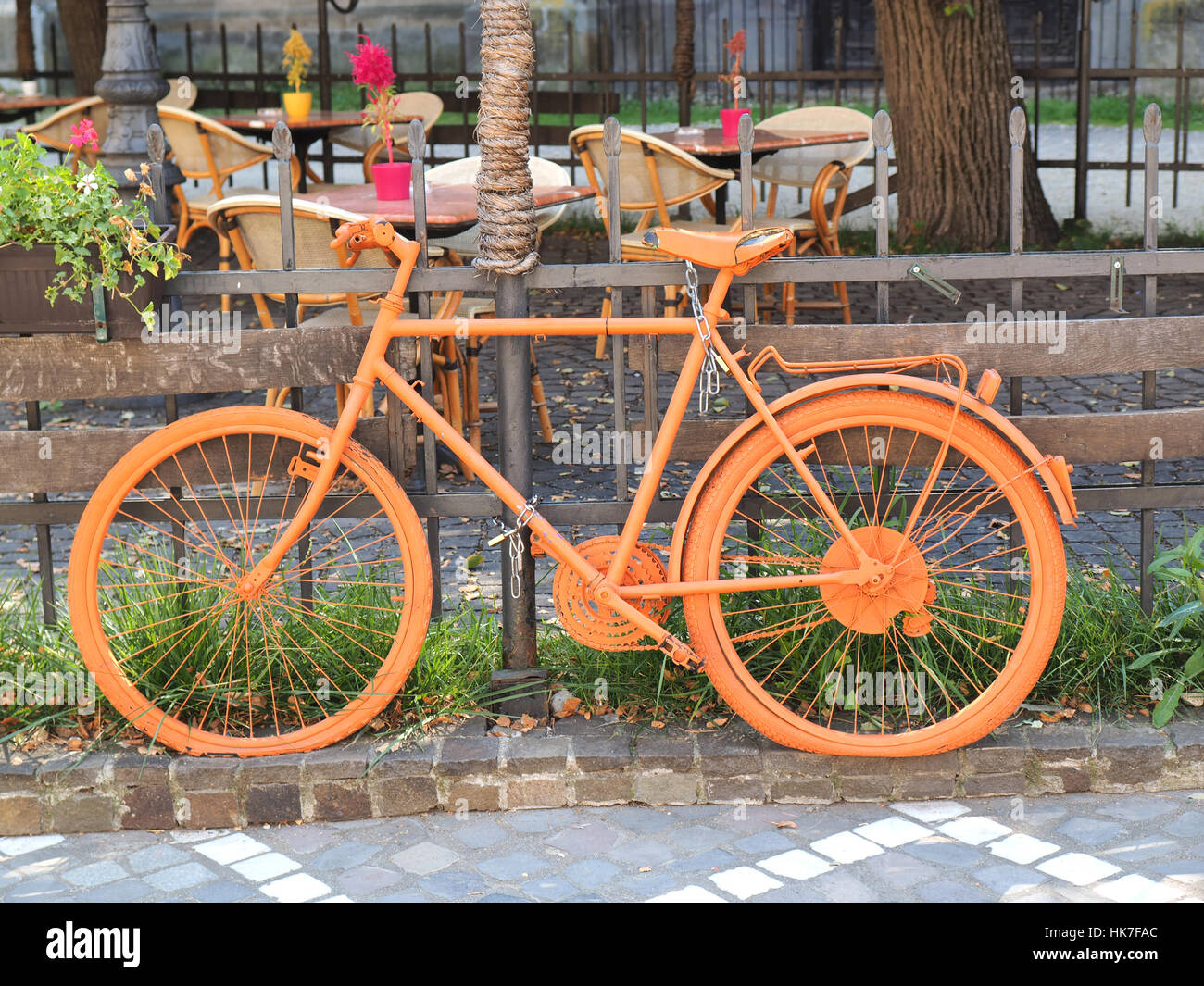 Photo de l'ancien vélo orange sur la clôture du coffee shop Banque D'Images