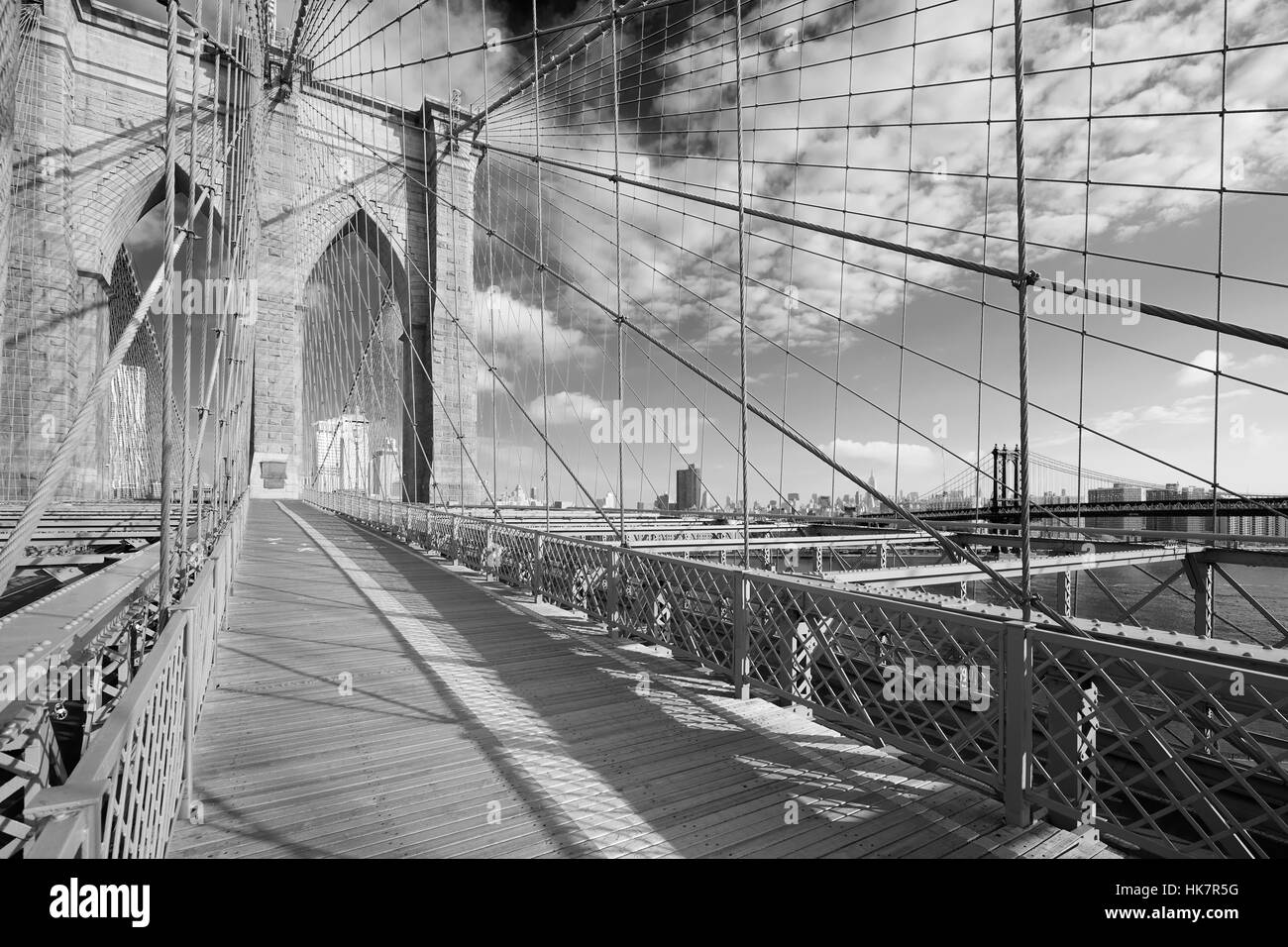Sentier du pont de Brooklyn vide dans une journée ensoleillée, New York en noir et blanc Banque D'Images