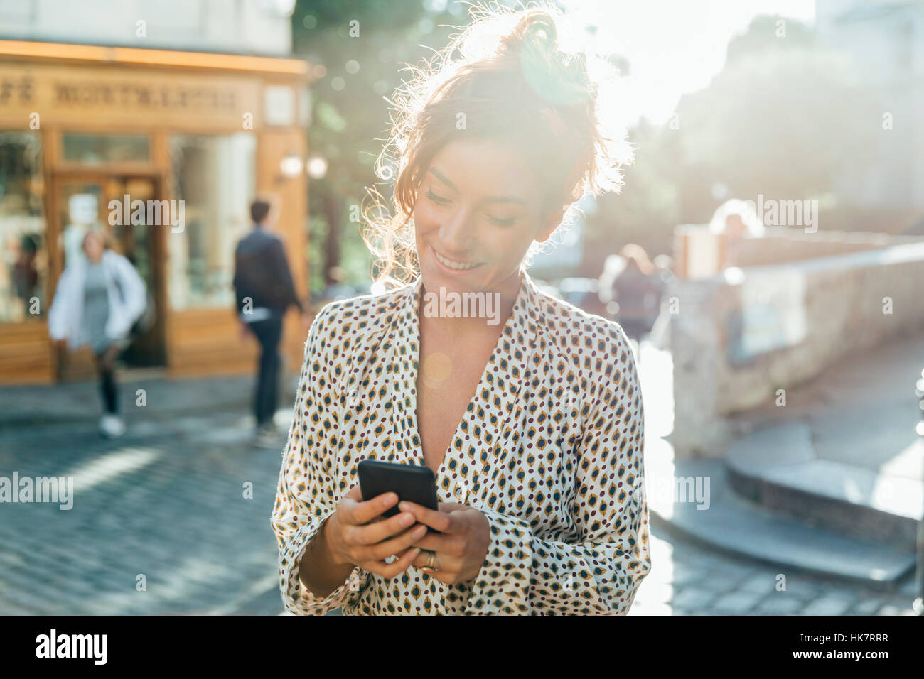 Paris, jolie femme visiter Montmartre et à l'aide d'un téléphone intelligent Banque D'Images