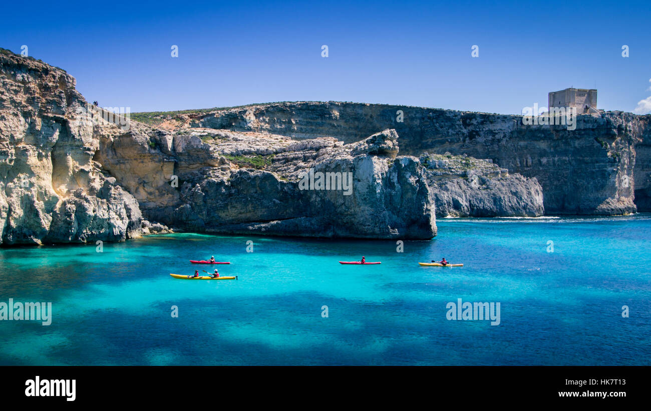 Groupe de personnes kayak dans la mer Méditerranée, l'eau claire avec un fond rocheux et de l'ensoleillement. Banque D'Images