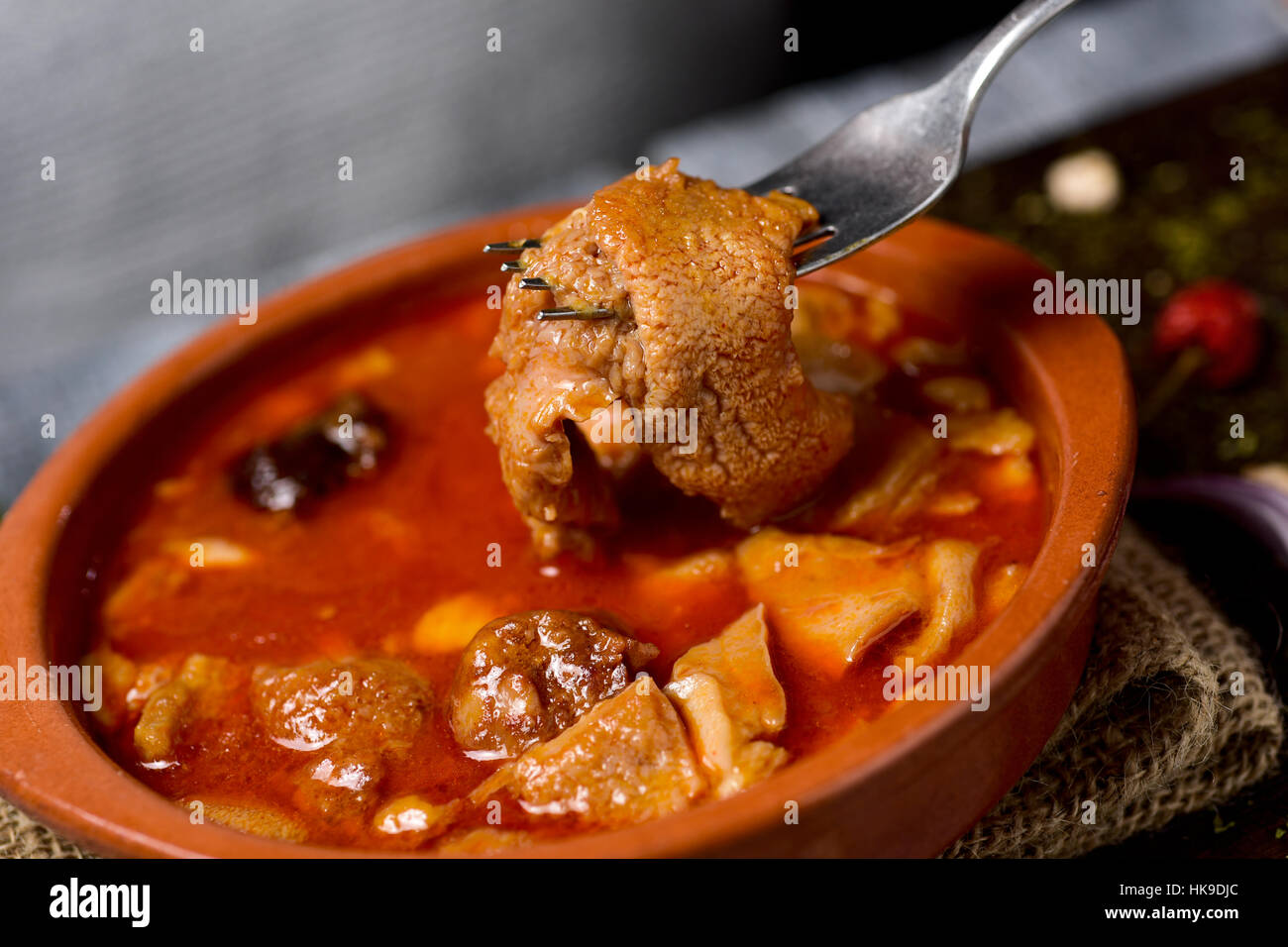 Libre d'un bol en terre cuite avec l'espagnol, un callos madriléne typique avec ragoût de pois chiches et chorizo, morcilla, sur une table en bois rustique Banque D'Images