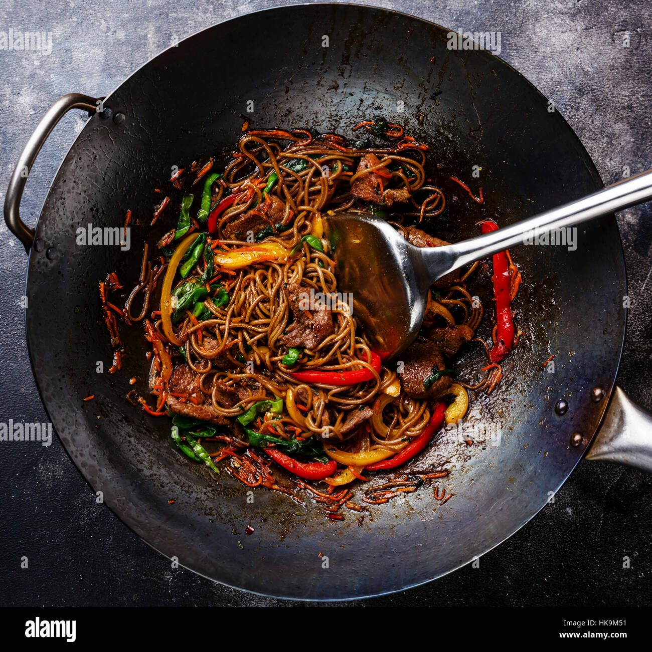 Faire sauter les nouilles soba au boeuf et légumes en wok casserole sur fond sombre close up Banque D'Images