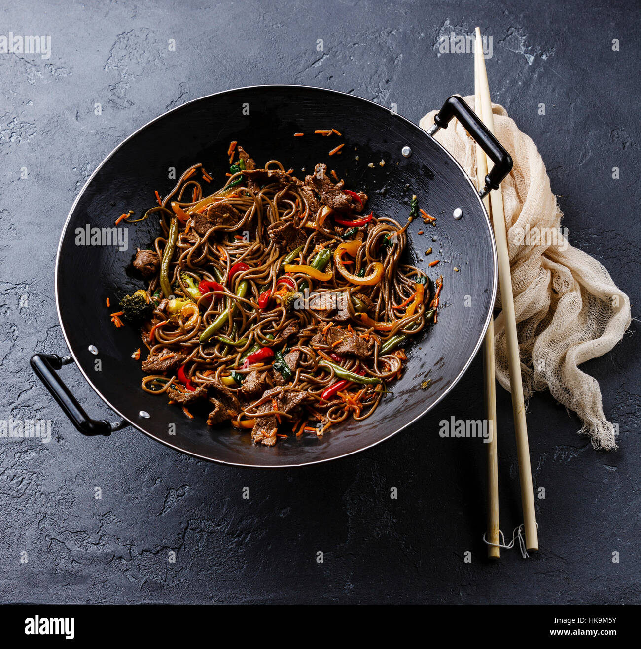 Yakisoba nouilles sautés au boeuf et légumes en wok casserole sur fond noir en sombre Banque D'Images