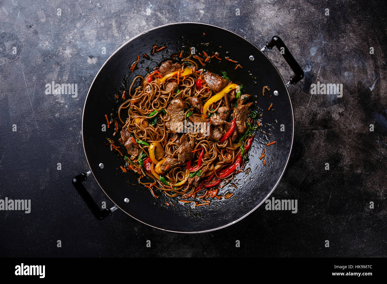 Faire sauter les nouilles soba au boeuf et légumes en wok casserole sur fond sombre Banque D'Images