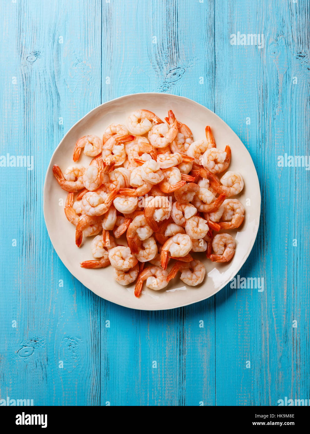 Crevettes crevettes sur plaque blanche sur fond bleu Banque D'Images