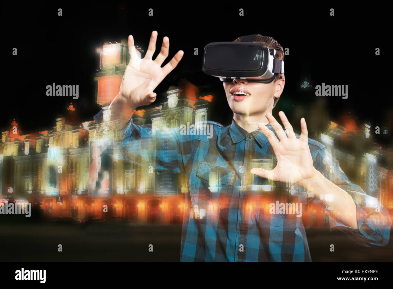 Double exposition de jeune homme à l'aide de casque VR pour lunettes lunettes de réalité virtuelle, de la ville de nuit. Banque D'Images