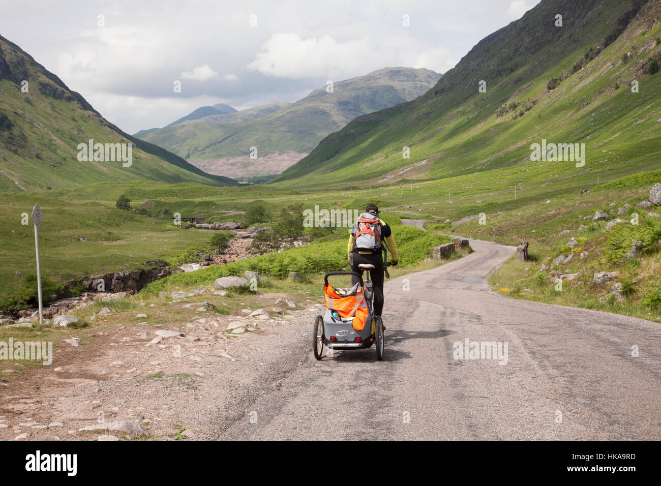 Homme randonnée à vélo sur la route à côté de la rivière Etive dans Glen Etive dans les Highlands, en Écosse. Banque D'Images