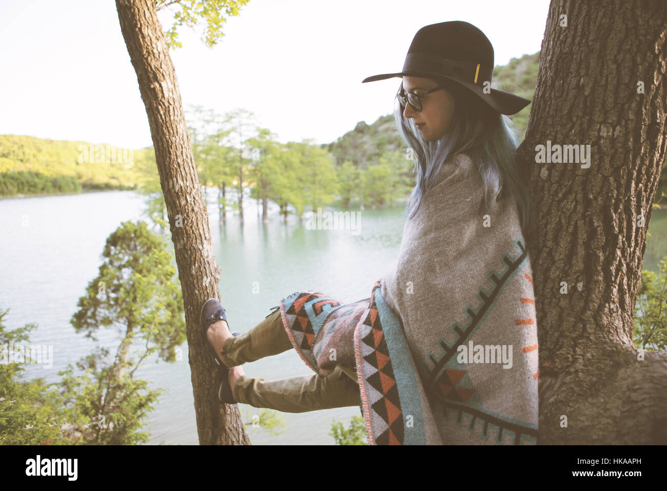 Jeune femme se reposant sur un arbre. Banque D'Images