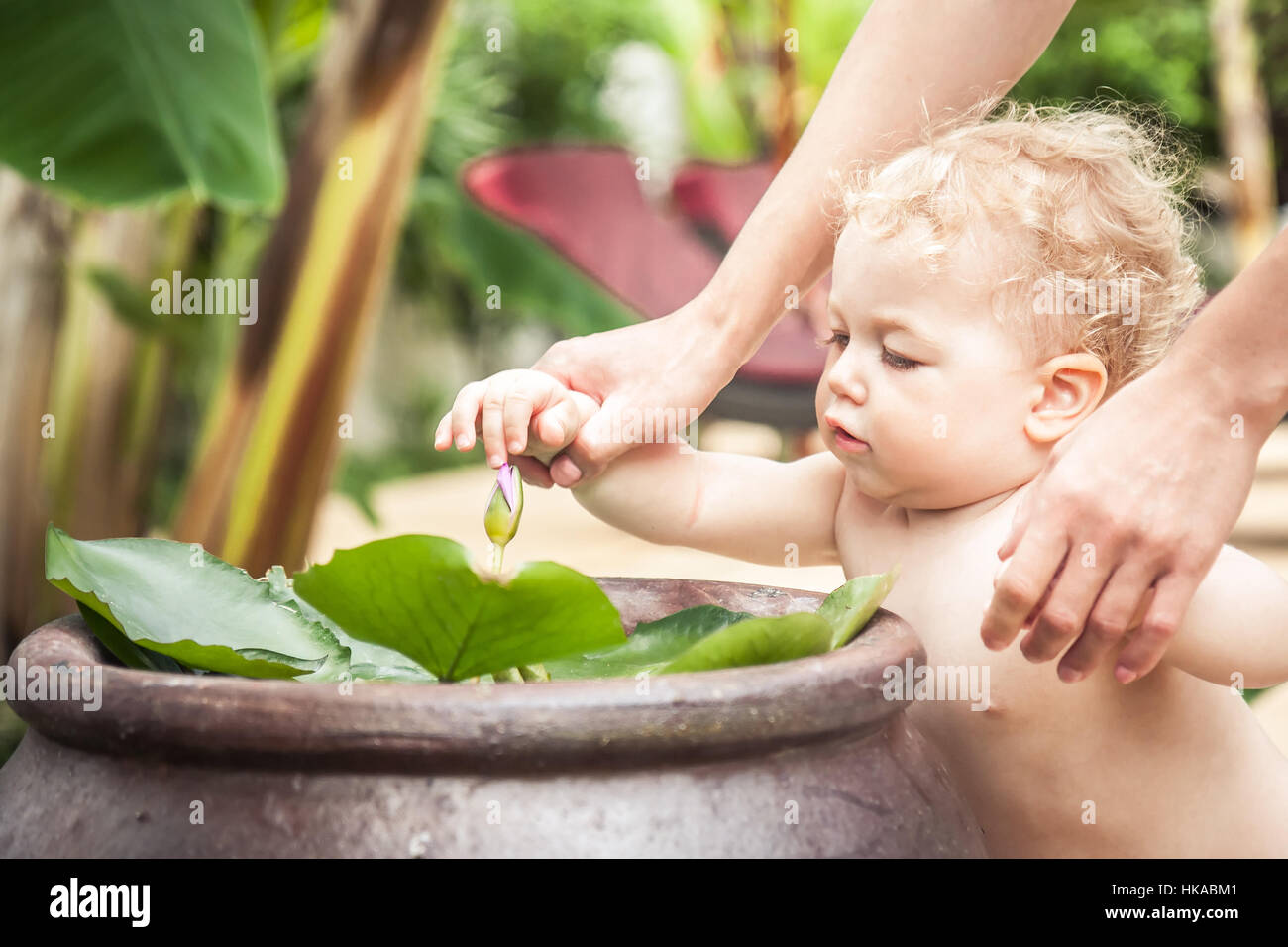 Bébé curieux avec la mère à la découverte de la flore dans le jardin tropical pendant les vacances Banque D'Images