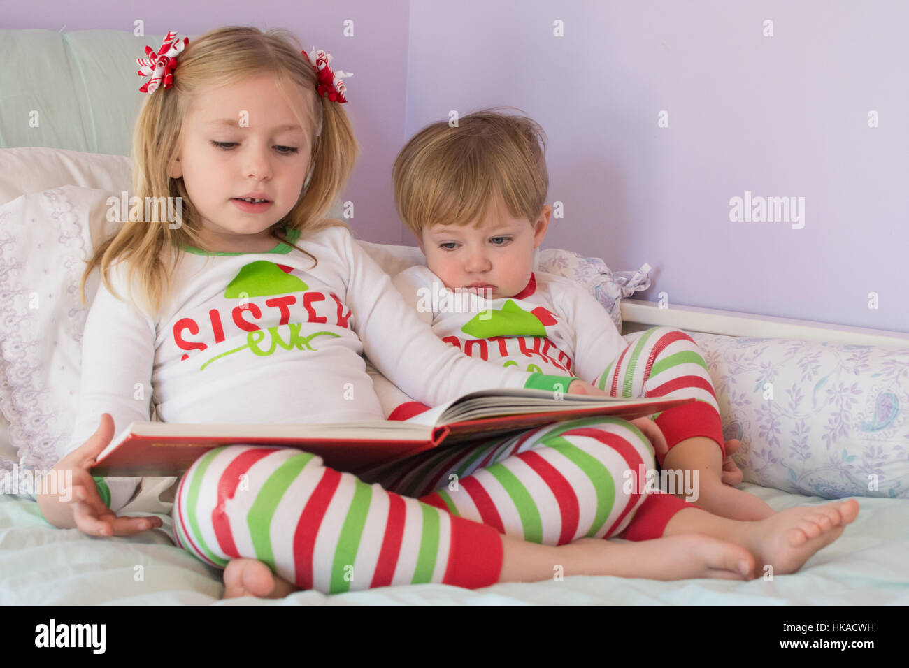 Frère et sœur adorable fratrie lecture histoire ensemble storytime vacances  de Noël pyjama correspondant Photo Stock - Alamy