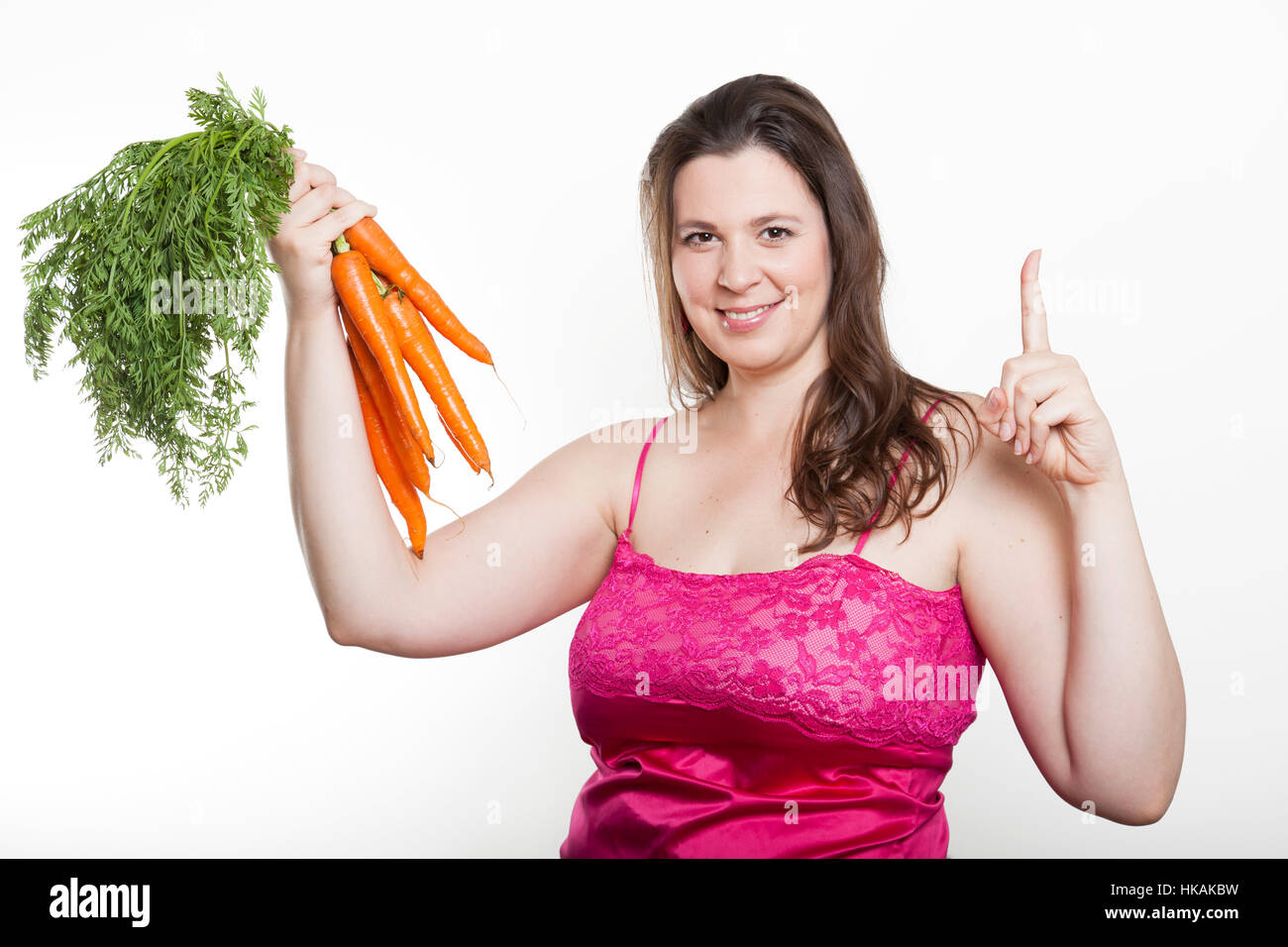 Femme tenant un bouquet de carottes et leurs index Banque D'Images