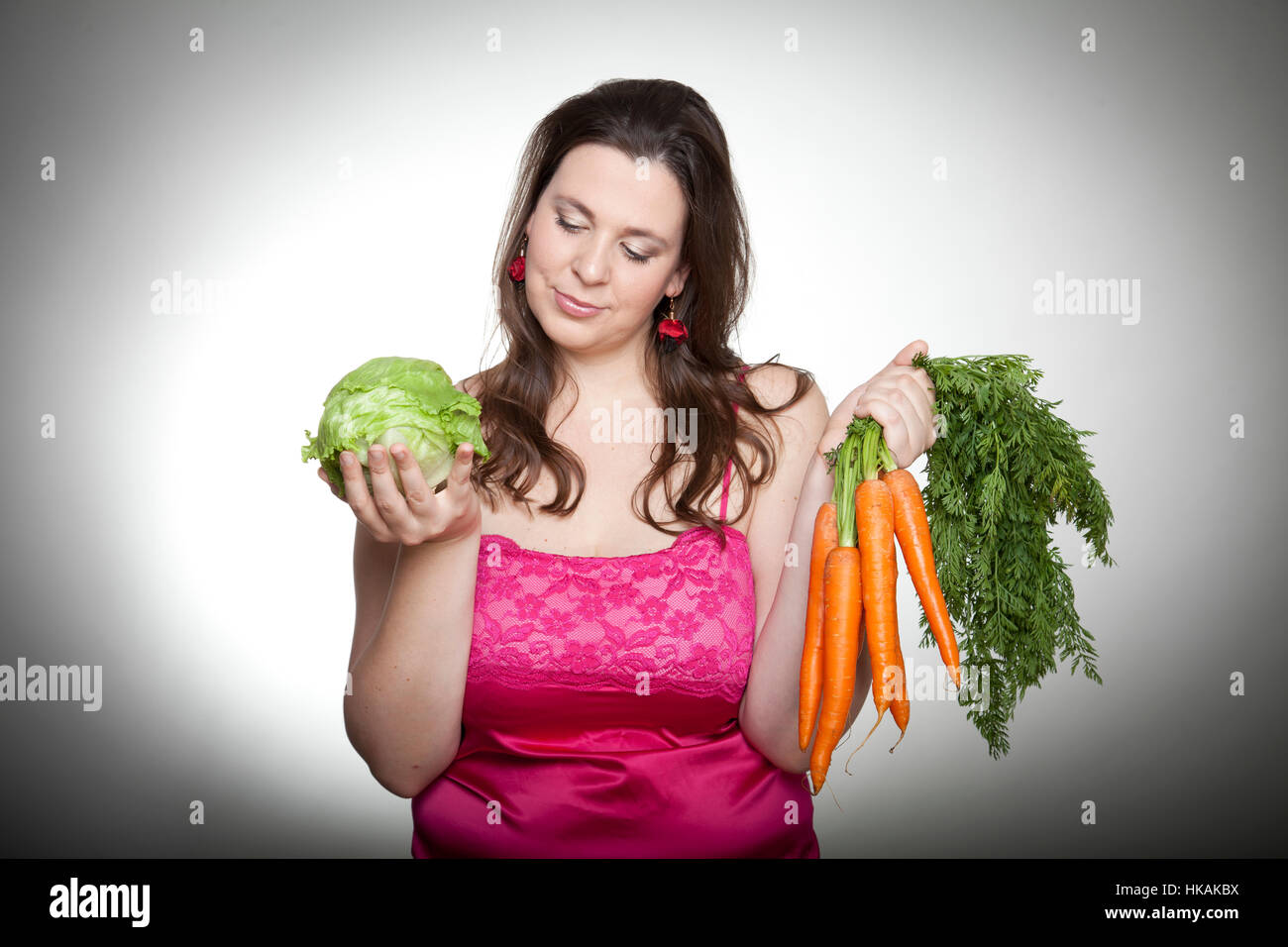 Surpondérés femme avec la laitue et les carottes Banque D'Images