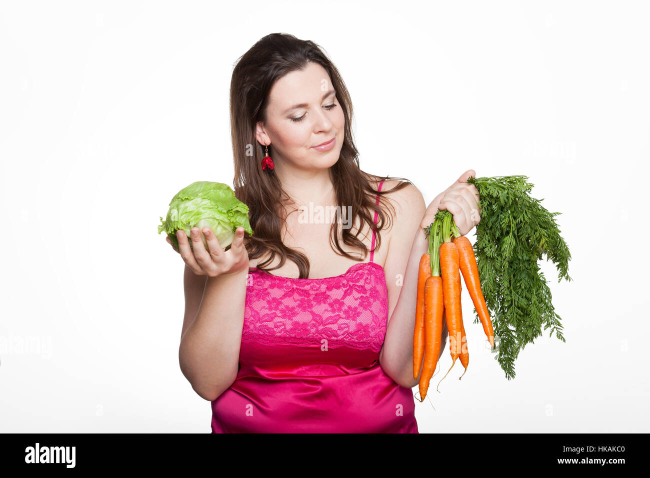 Surpondérés femme avec la laitue et les carottes Banque D'Images