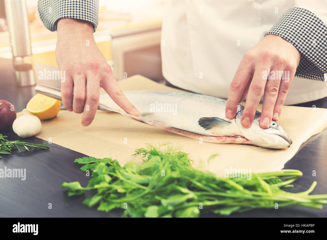 Chef de la préparation du poisson pour la cuisson du saumon dans la cuisine Banque D'Images
