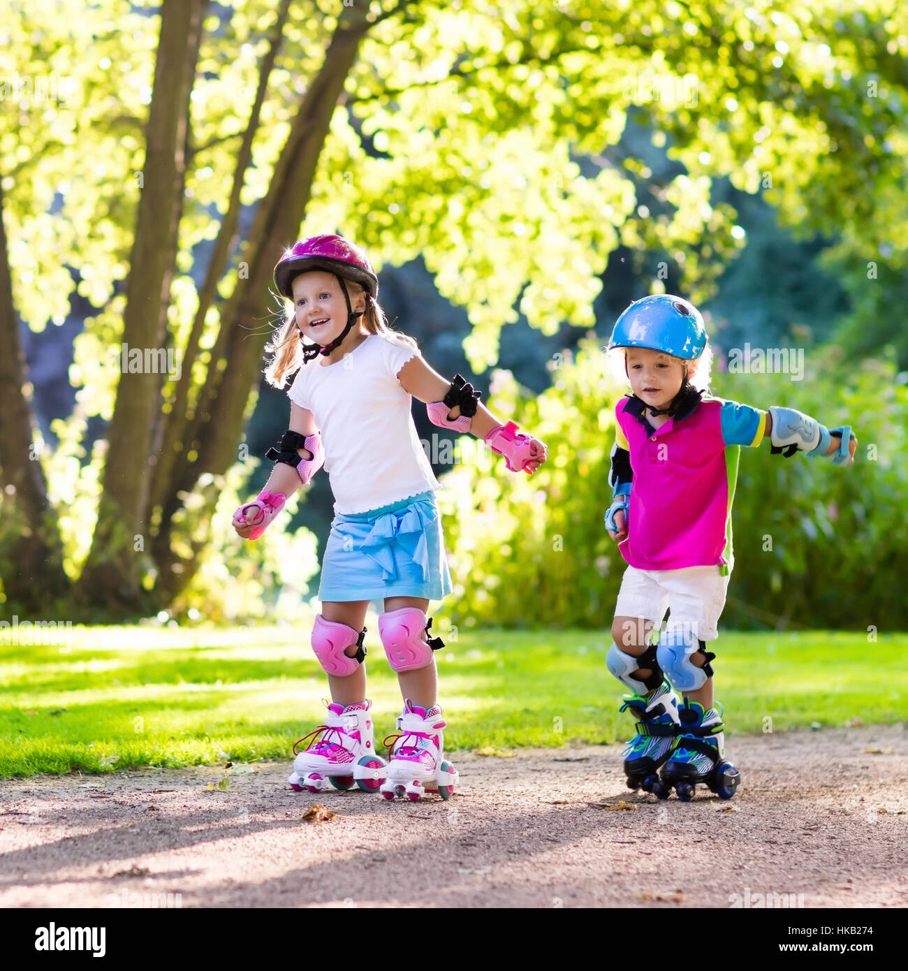 Fille et garçon apprendre à roller skate parc en été. Les enfants portant  des patins de protection et casque de sécurité pour l'utilisation  sécuritaire de roller Photo Stock - Alamy