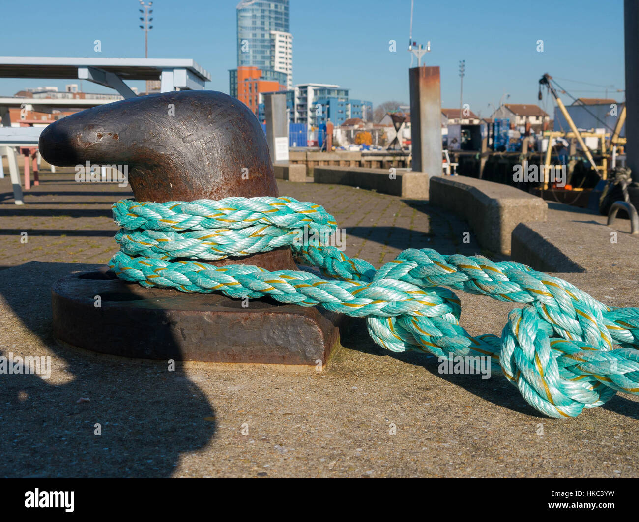 L'homme a fait une corde en fibre de l'obtention d'un bollard bateau sur une jetée Banque D'Images