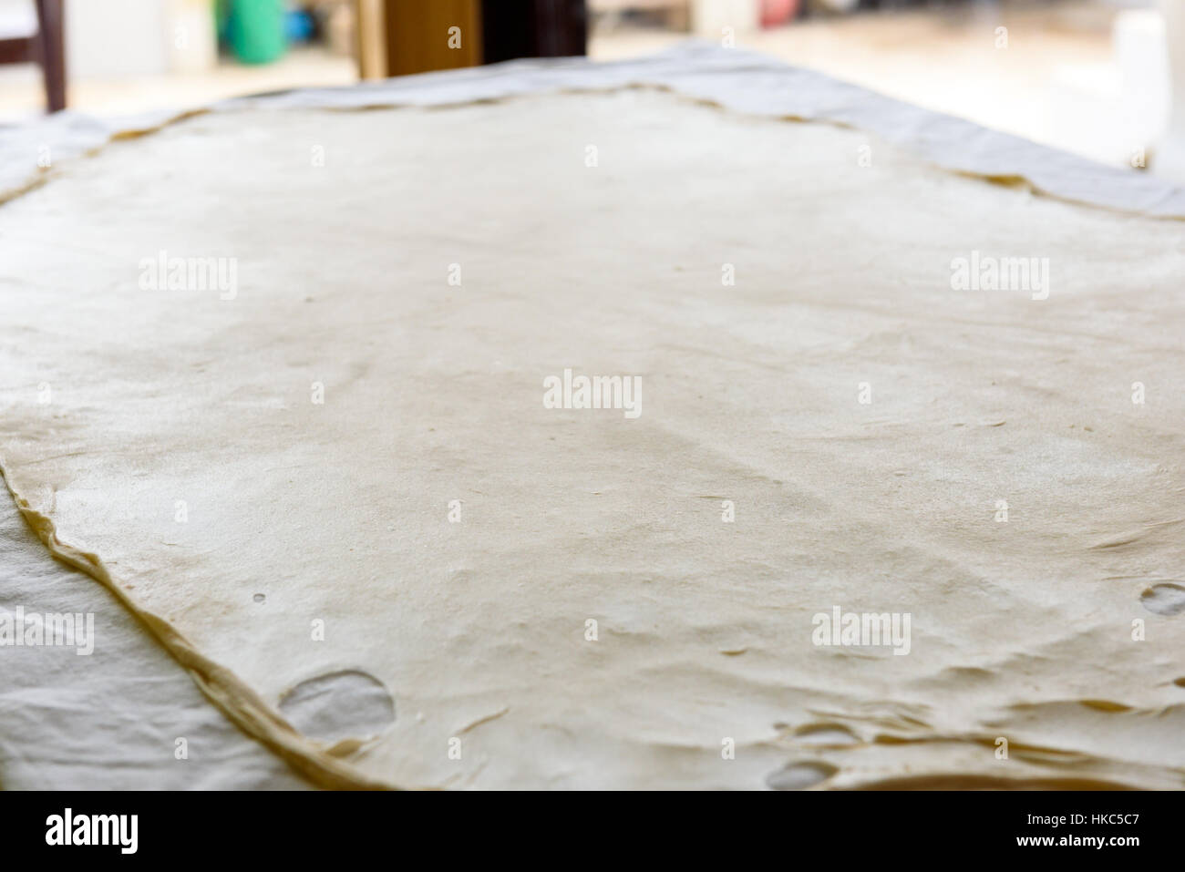 Pâte filo strudel faits maison ou de pâte sur un tapis de table d'accueil, prêt à l'Apfelstrudel, baklava, Burek, tarte ou autre type de pâtisserie traditionnelle. Banque D'Images