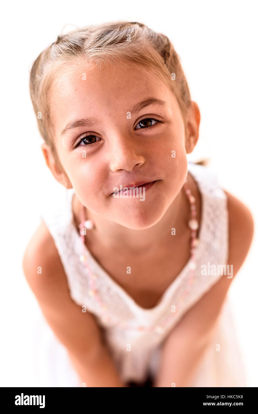 Portrait d'une petite fille aux tresses, souriant. Enfant de tresses, est à la recherche de l'appareil photo. Banque D'Images