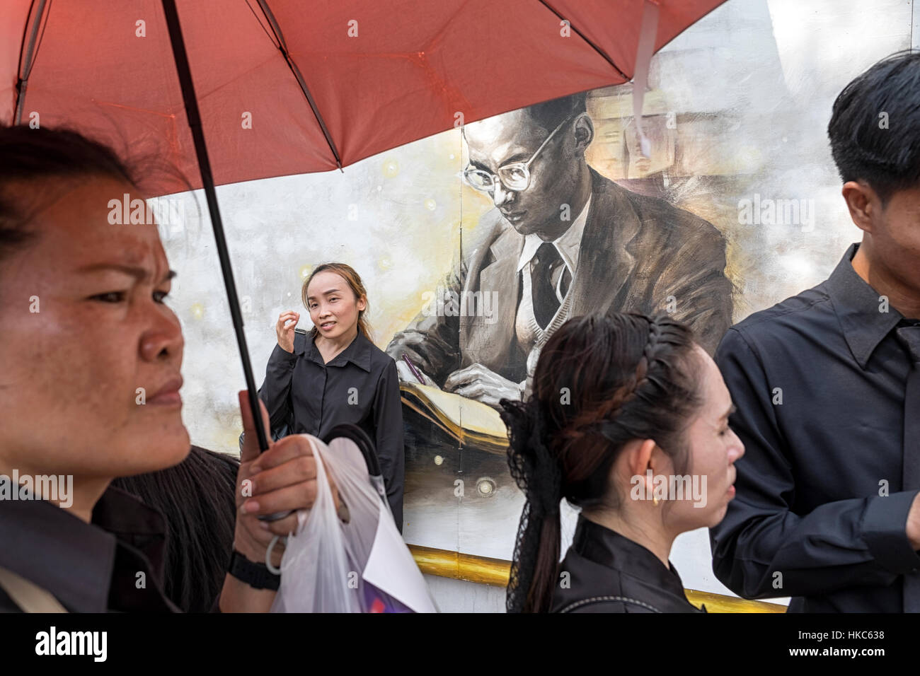 Les hommes et les femmes se faire photographier à côté d'un portrait représentant le Roi Bhumibol Adulyadej Banque D'Images