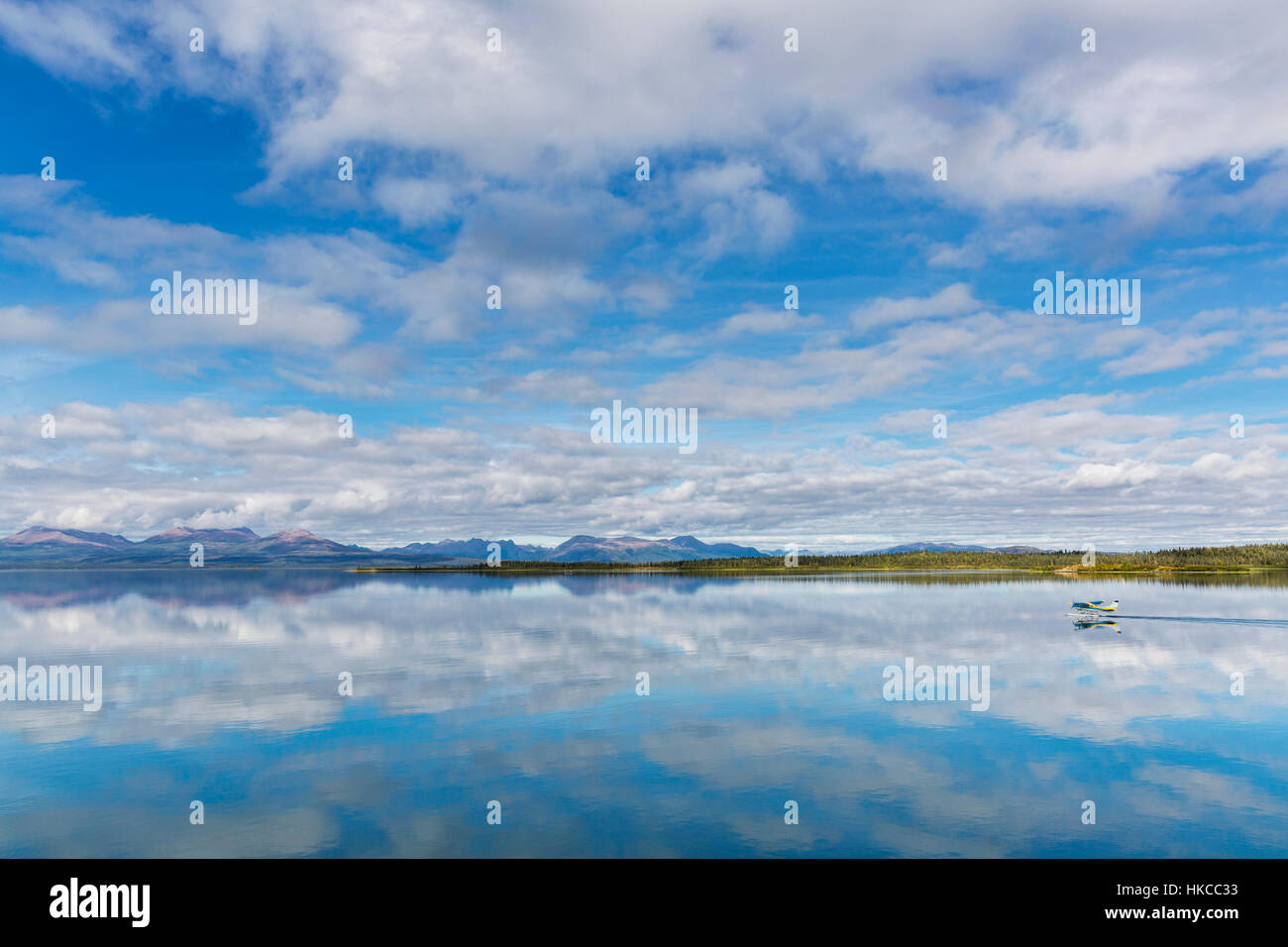 De légers nuages reflètent sur l'eau calme du lac Tikchik au Tikchik Narrows Lodge, Bois Tikchik State Park, le sud-ouest de l'Alaska Banque D'Images